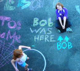 Dakota sitting amidst the chalk art. Bob is the name of her pet goldfish. Bailee is playing with the Hula Hoop.