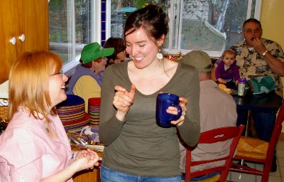 Sue and Megan laugh while everyone else eats snacks while laughing - photo.